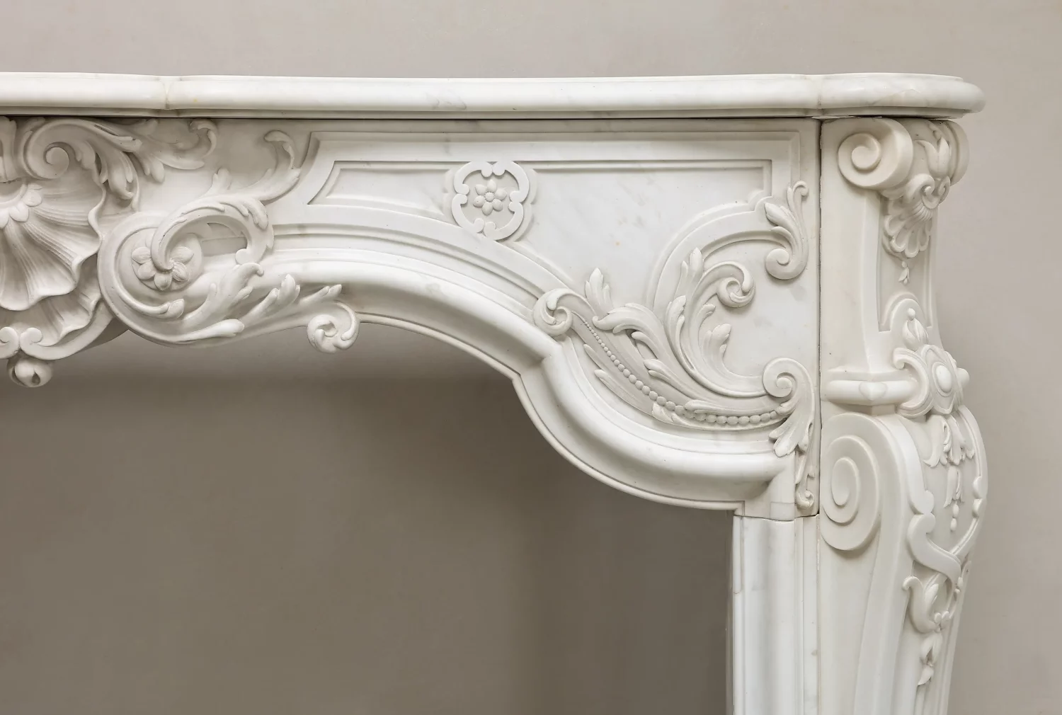 Detail van bladmotieven, bloemornament en parelrand aan de rechterkant van de witmarmeren bovendorpel.