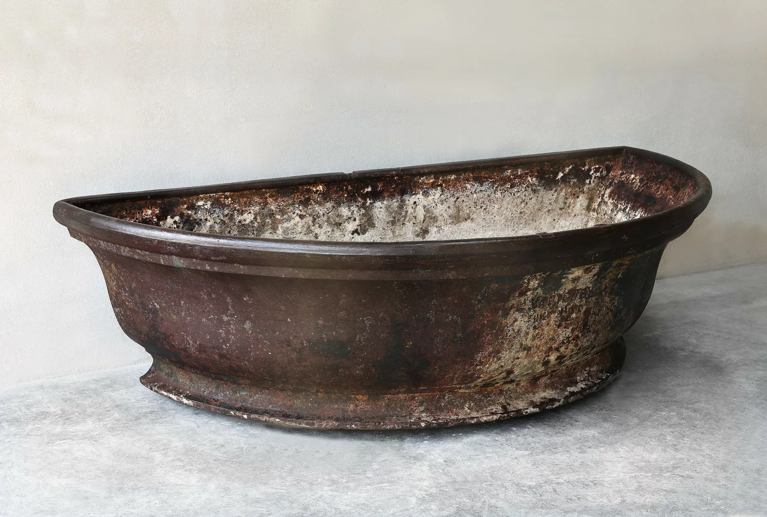 Zijaanzicht van antieke gietijzeren trog, circa 1880–1920, met zicht op diepte en proporties